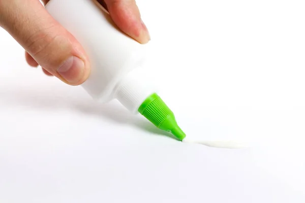 Mão segurando uma garrafa de cola. Lida com cola PVA no papel. Isolados — Fotografia de Stock