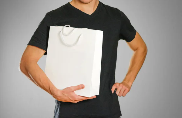 Killen håller en vit presentpåse — Stockfoto