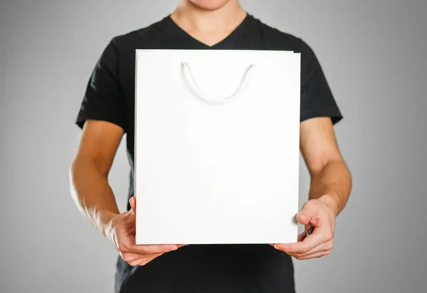 El tipo sostiene una bolsa de regalo blanca —  Fotos de Stock