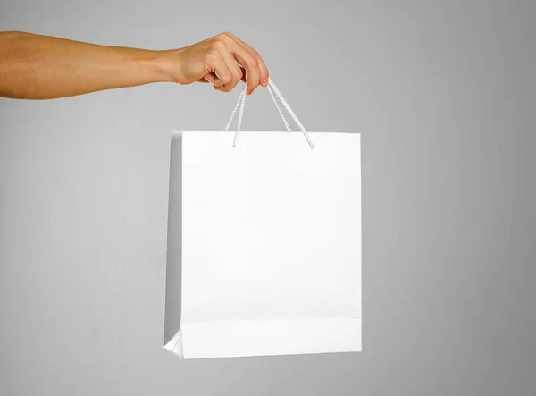 La mano sostiene una bolsa de regalo blanca — Foto de Stock