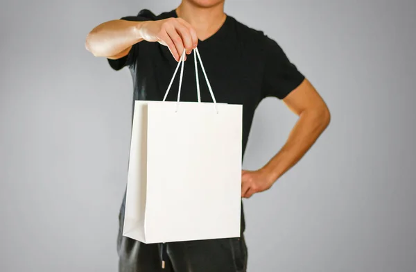 El tipo sostiene una bolsa de regalo blanca — Foto de Stock