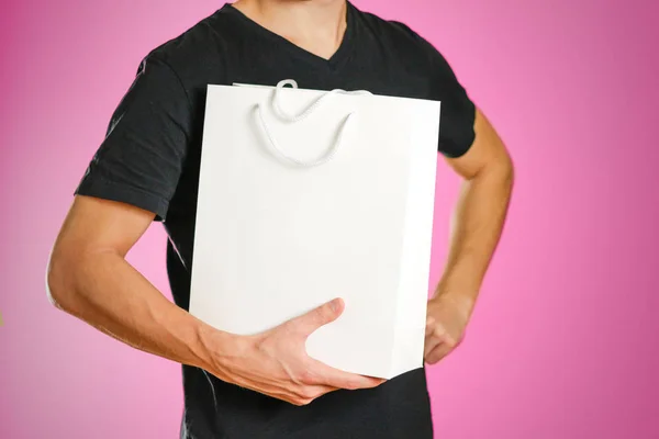 Парень держит белый подарочный пакет — стоковое фото