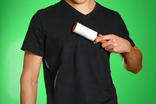 Guy brushing his black t-shirt from debris sticky roller — Stock Photo, Image