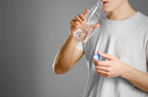 Jongen drinkwater uit doorzichtige plastic flessen — Stockfoto