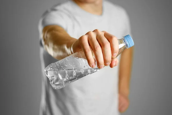 The guy is holding a clear plastic water bottle — Stock Photo, Image