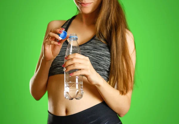 La ragazza sta tenendo una bottiglia d'acqua di plastica trasparente — Foto Stock