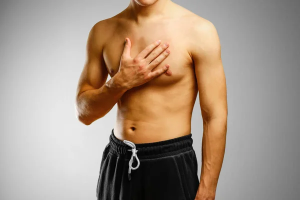 Killen med ingen skjorta som håller hand av patientens bröst. Smärtan — Stockfoto