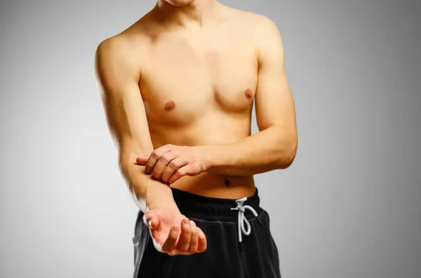 The guy with no shirt scratching his arm. Itching in hand — Stock Photo, Image