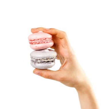 El beyaz bir arka plan üzerinde renkli macaroons tutar. Portre