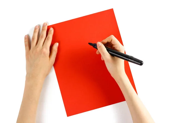 Hand holding black marker on red paper on a white background. Cl — Stock Photo, Image