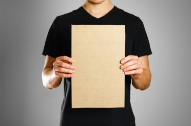 Siyah t-shirt bir karton parçası tutan genç bir adam. Öncesi