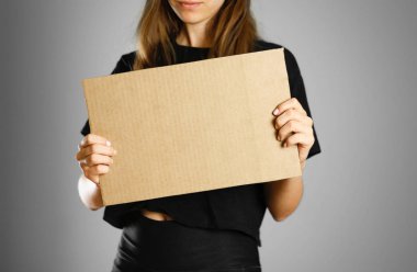 Bir karton parçası tutan siyah t-shirt bir genç kız. PR