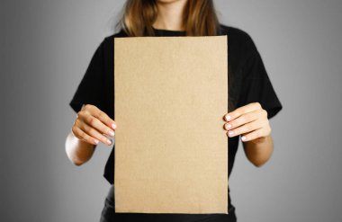 Bir karton parçası tutan siyah t-shirt bir genç kız. PR