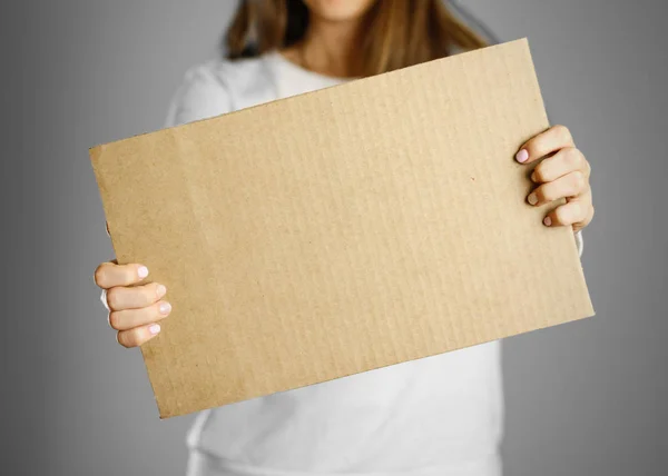 Молодая девушка в белом пиджаке держит кусок картона. Пре — стоковое фото