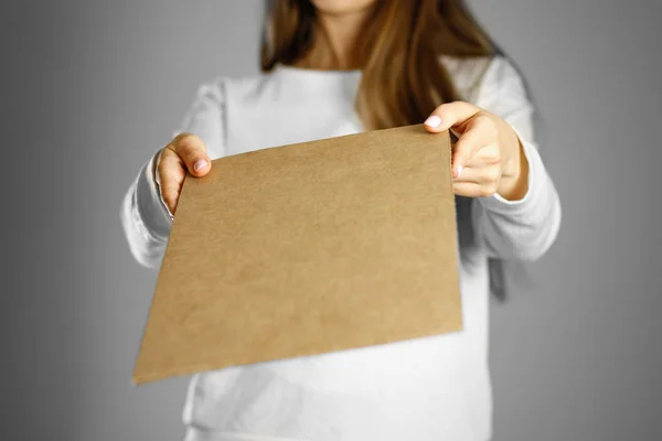 Una joven con una chaqueta blanca sosteniendo un pedazo de cartón. Antes de — Foto de Stock