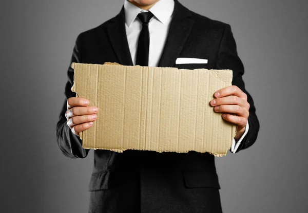 Uomo d'affari in completo nero, camicia bianca e cravatta con un pezzo in mano — Foto Stock