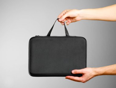 Siyah bir durumda holding eller. Gri arka plan üzerinde izole