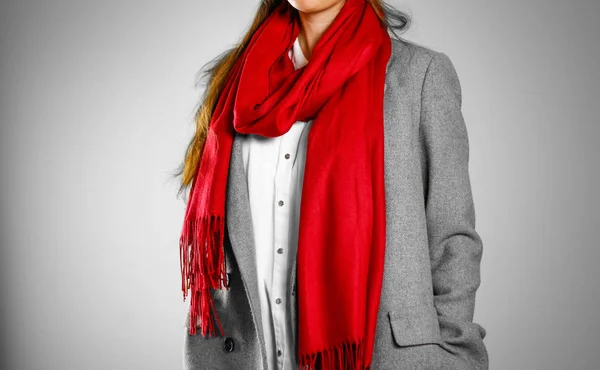 Lány a szürke kabátot és a piros kendő. Elszigetelt, a szürke háttér — Stock Fotó