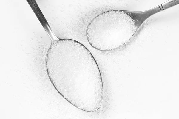 Zucchero in due cucchiai. Chiudete. Isolato su sfondo bianco — Foto Stock