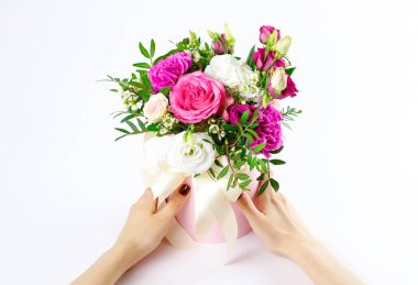 Kompozisyon bir pembe şapka çiçek dolu. Geniş beyaz RI ile bağlı