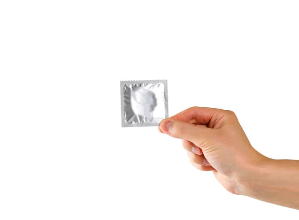 Рука людини тримає єдиний презерватив. Близько. Ізольовані на білому — стокове фото