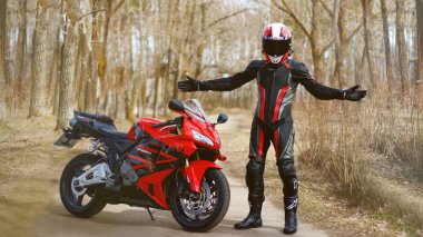 Krasnoyarsk, Rusya - 21 Nisan 2018: Güzel motosikletçi tam dişli ve bir kırmızı ve siyah Honda 2005 Cbr 600 Rr (Pc37 kask).