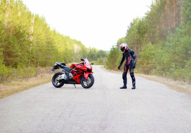 Krasnoyarsk, Rusya - 27 Nisan 2018: Güzel motosikletçi tam dişli ve bir kırmızı ve siyah Honda 2005 Cbr 600 Rr (Pc37 kask)
