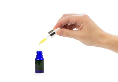 Pipette küçük mavi bir şişeye damlıyor. Kapatın. İzole edilmiş olarak.