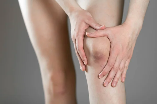 Siniak na kolanie. Ból kolana. Kobieta trzyma nogę. Klosy — Zdjęcie stockowe