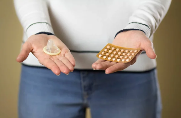Дівчина тримає таблетки контролю над презервативами та народжуваністю. крупним планом — стокове фото