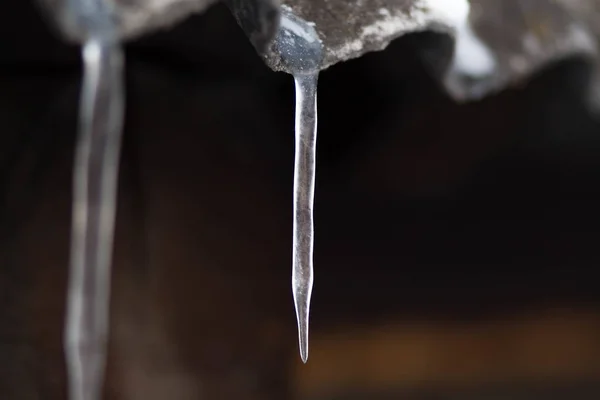 Icicles hang on the old roof. Close up — Stock Photo, Image