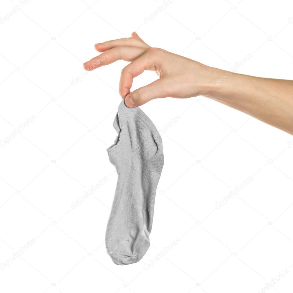 Hand holds dirty smelly sock. Close up. Isolated on a white back