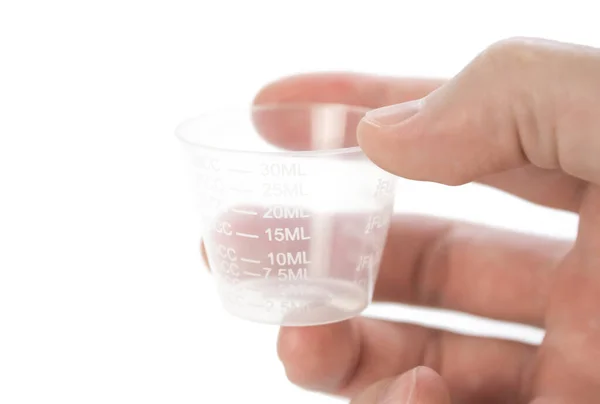 Hand holding a measuring Cup. Close up. Isolated on a white back — Stock Photo, Image