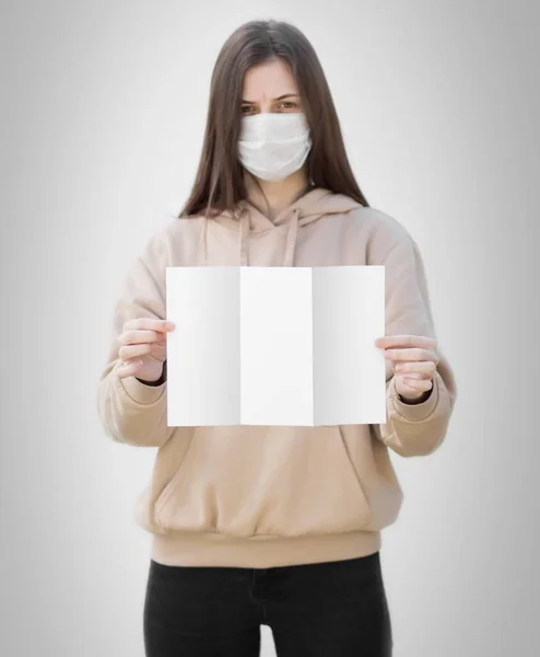 Uma Rapariga Com Uma Máscara Médica Tem Uma Folha Papel — Fotografia de Stock