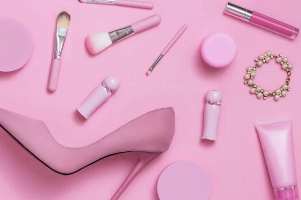 Layflat image of pink womans fashion and cosmetics products.