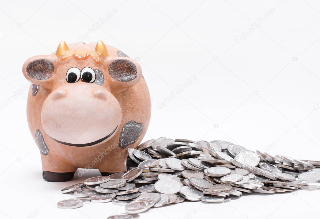 Piggy bank and coins over white background.