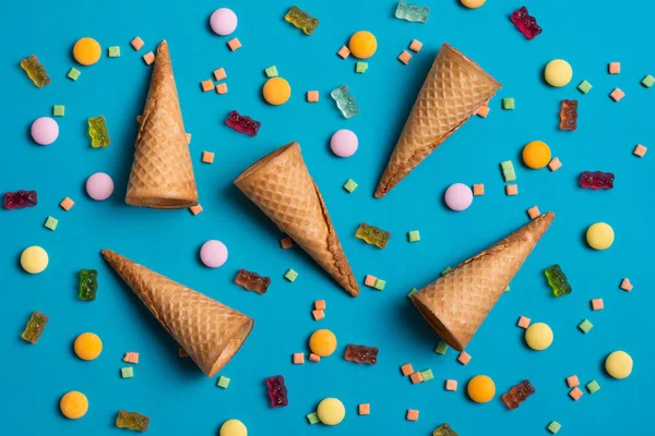 Cones de sorvete e doces sobre fundo azul . — Fotografia de Stock