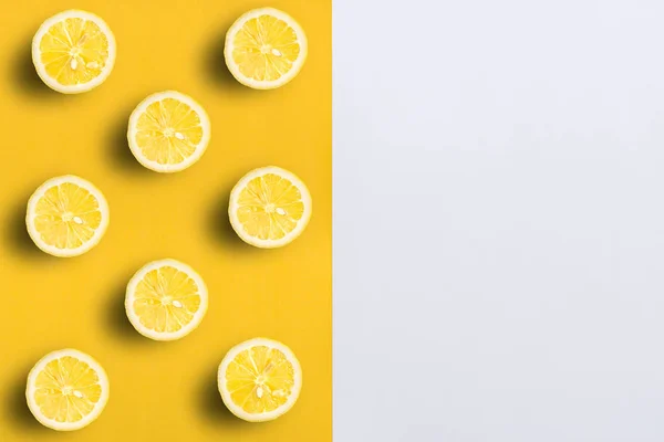 Moitiés de citron sur couleur fendue, fond jaune et blanc avec co — Photo