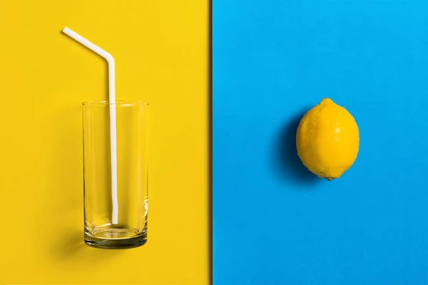 Limões em fundo colorido dividido com vidro e palha . — Fotografia de Stock