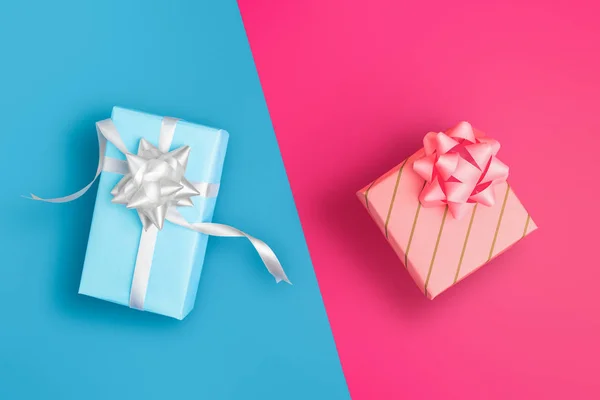 Zijn en haar, blauw en roze verpakt cadeautjes op gekleurde achtergrond — Stockfoto