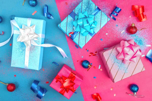 Presents wrapped in brightly colored blue pink and red paper with glitter ribbons and other decorations — Stock Photo, Image