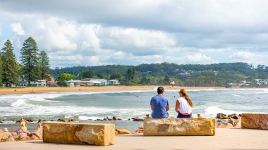 20th Feb 2020 - Avoca Beach NSW, Australia : Man and a woman share a scenic beach view while having a coffee - outdoors lifestyle travel concept editorial image. clipart