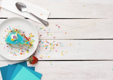 Üzerine konfeti serpiştirilmiş renkli bir kek dilimi bir kaşık ve çilek serpiştirir. Düz yiyecekler serer, metin için fotokopi alanı ile konsept resim hazırlar..