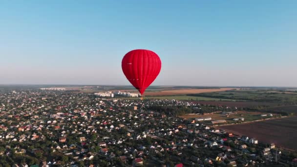 傍晚时分 一个美丽的红色气球飞越了河流和城市 — 图库视频影像