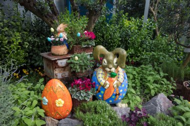 Bahçedeki güzel Paskalya tavşanı. Paskalya yumurtaları. Büyük turuncu paskalya yumurtası. Bahçe.