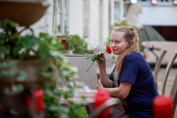 Gyönyörű Lány Kék Pólóban Vörös Rózsával Egy Üres Étteremben Függőben — Stock Fotó