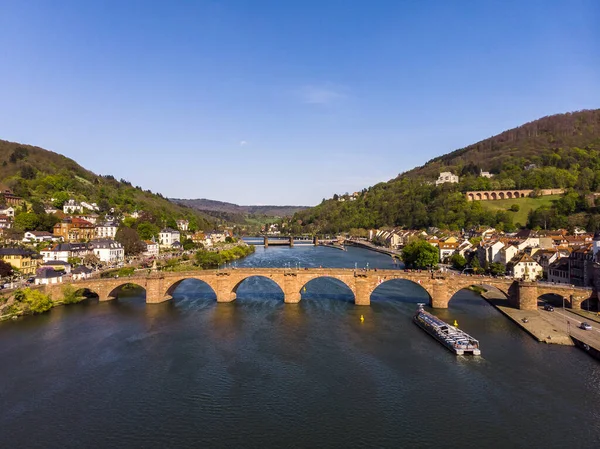 Beautiful top view of the pedestrian bridge over the river and the old part of the city. Spring. Green leaves on the trees. Nekka River. Beautiful mountains. Heidelberg. Germany.