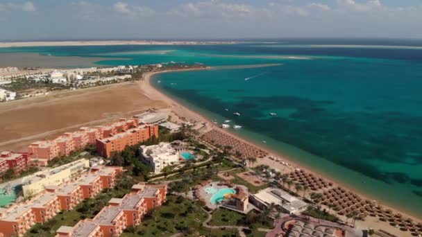 从上面飞越酒店和靠近Hurghada的沙漠 俯瞰住宅建筑 为游客提供游泳池 沙漠中央美丽的土地 清澈的大海尽收眼底 — 图库视频影像