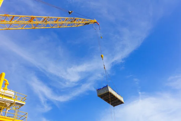 Crane boom while lifting basket in the sea