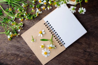 Boş defter ile beyaz çiçek ve bas ket çiçek vintage ahşap Tablo görünümü yukarıdan kopya alanı